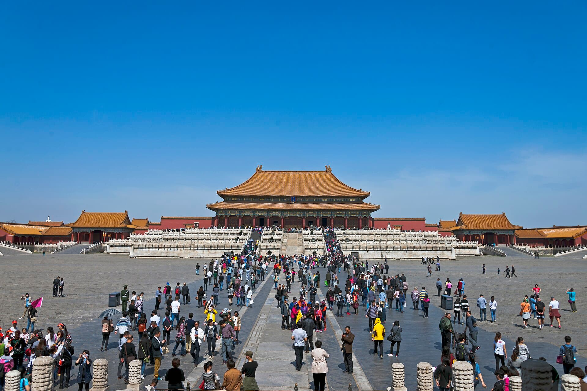 The crowds actually help reveal the point: the ceremonial halls make people feel small by design.