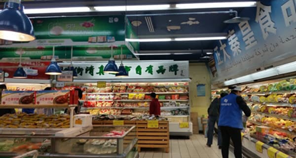 The supermarket makes Niujie feel practical: families shop here, visitors graze here, and takeaway is part of the fun.
