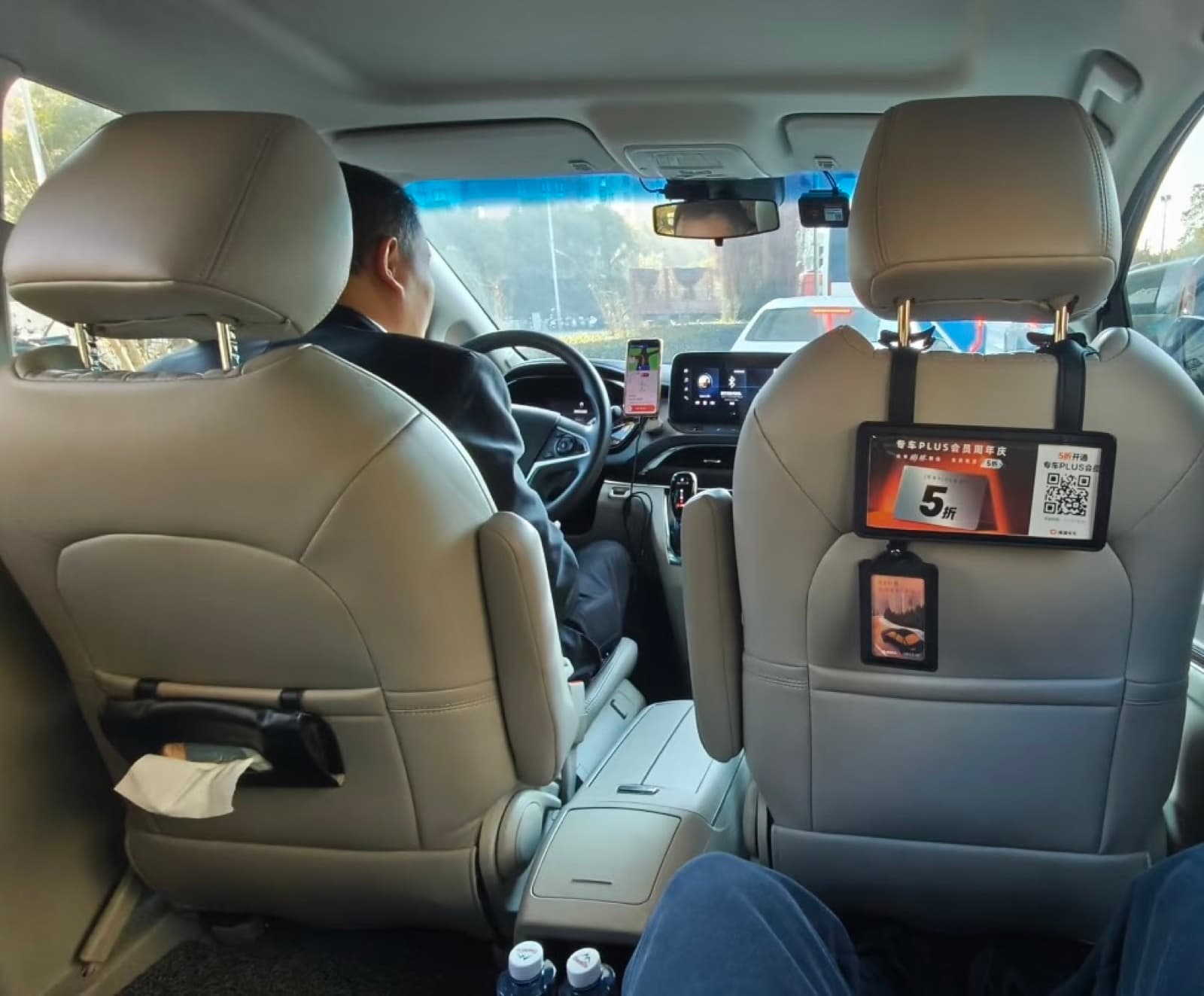 View from the back seat of a Chinese ride-hailing car with the driver's phone mounted on the dashboard