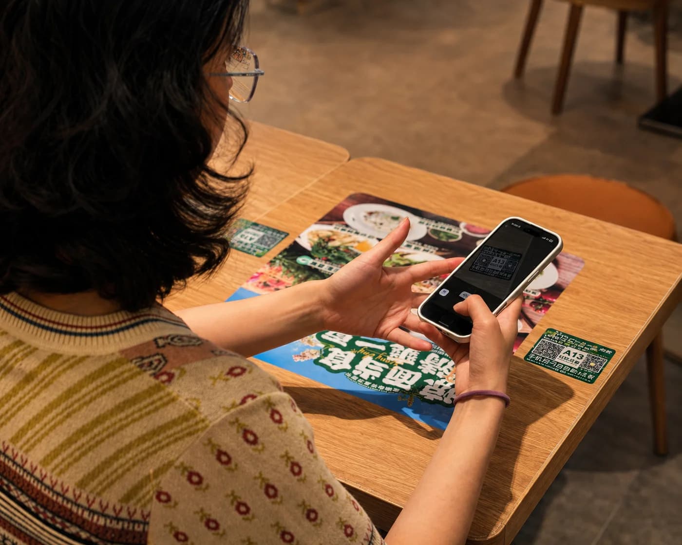 Yadi pointing her phone at the code on a restaurant table