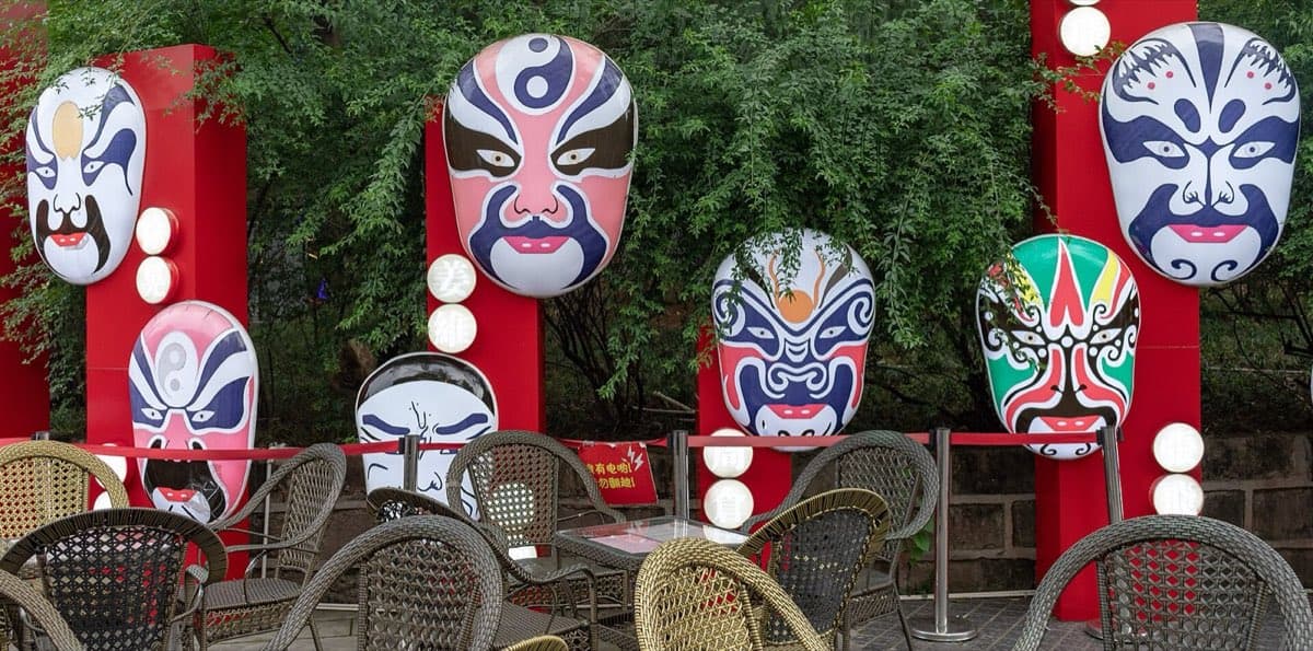 Mask imagery appears all over Chengdu, but the live stage gives it motion and tension.