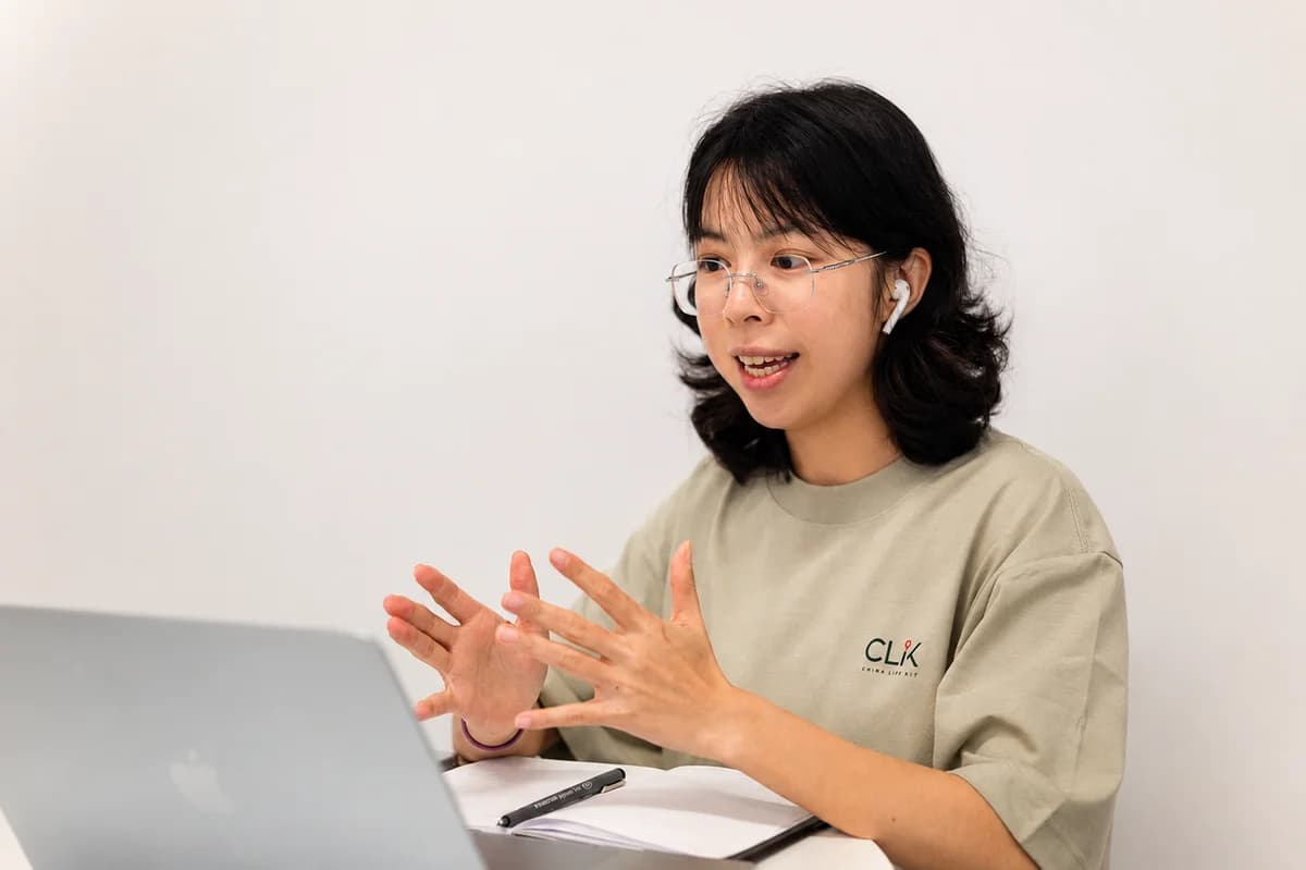Yadi talking beside her laptop and notebook